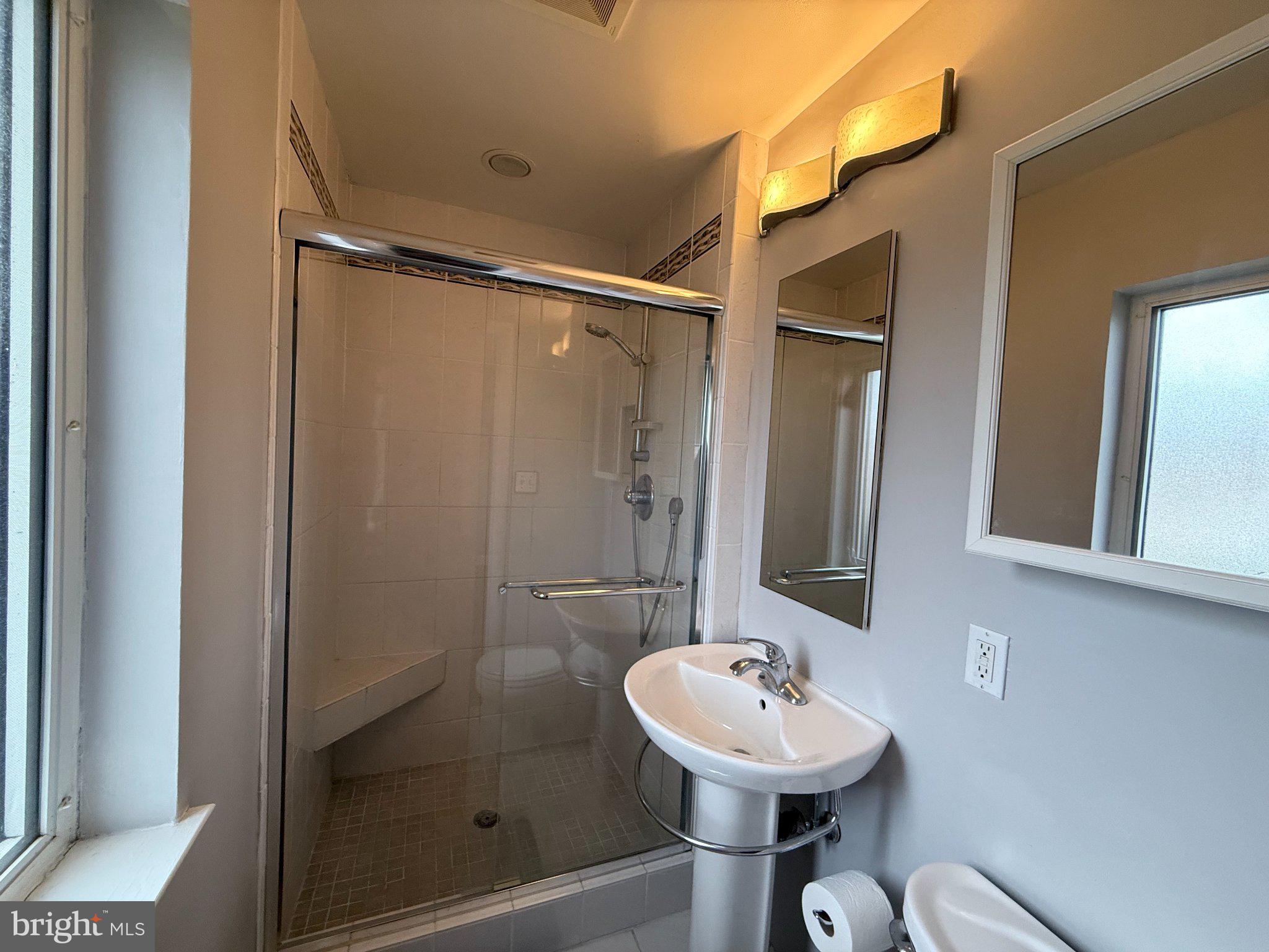9709 Saxony Road Silver Spring, MD 20910 - Photo 25 of 47 a bathroom with a sink mirror and shower