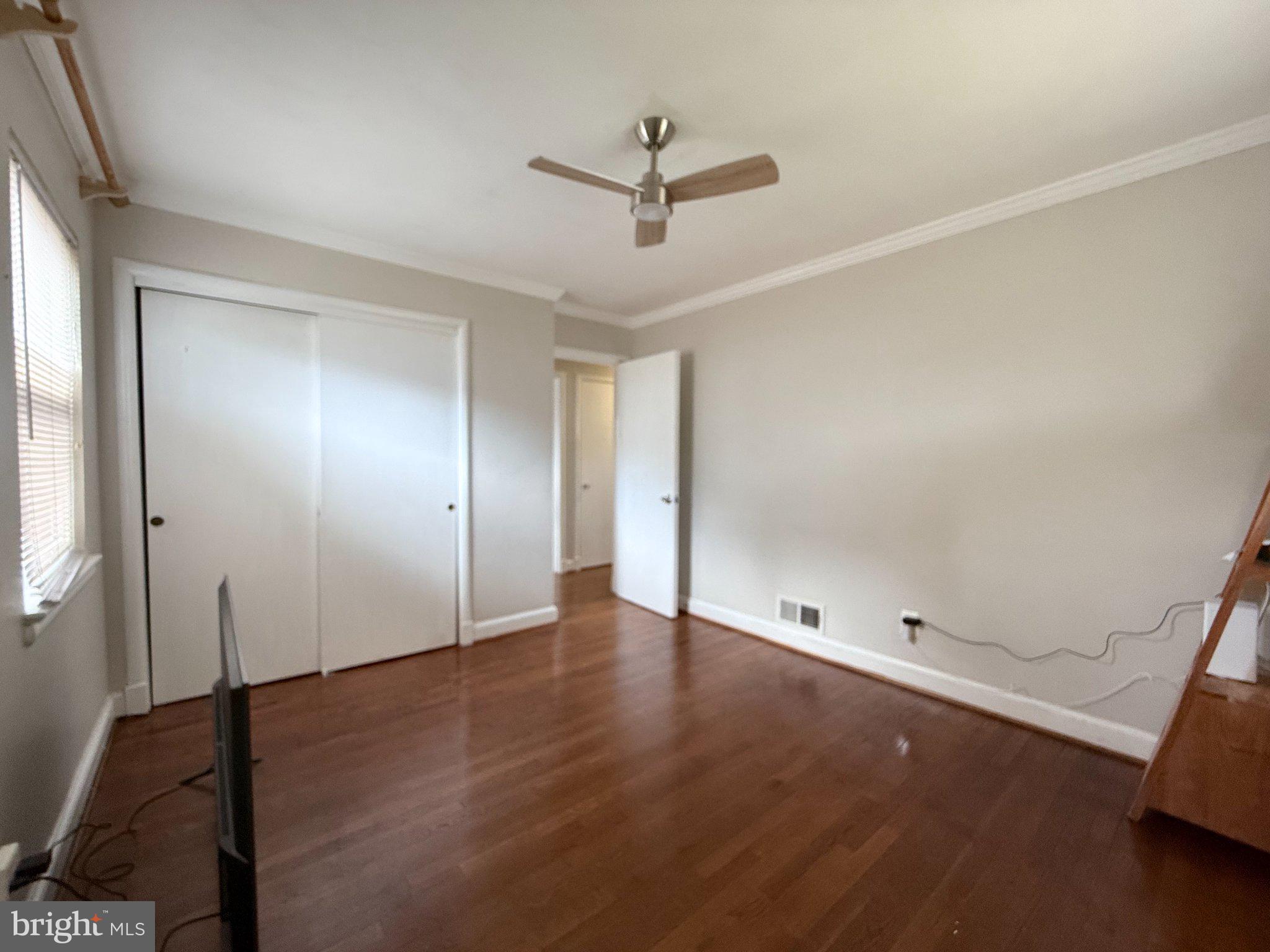 9709 Saxony Road Silver Spring, MD 20910 - Photo 26 of 47 an empty room with wooden floor and ceiling fan