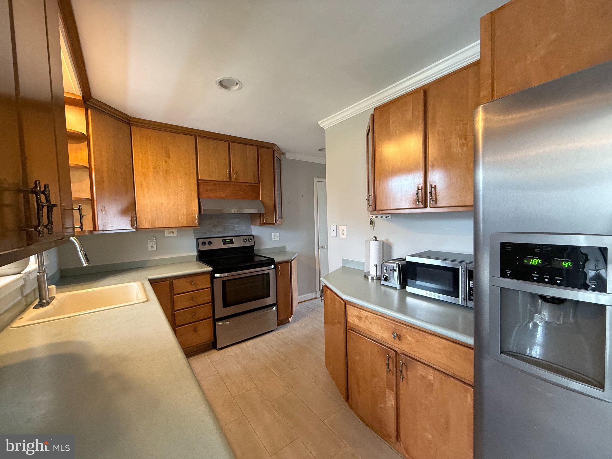 9709 Saxony Road Silver Spring, MD 20910 - Photo 10 of 47 a kitchen with stainless steel appliances granite countertop a stove a sink and a microwave