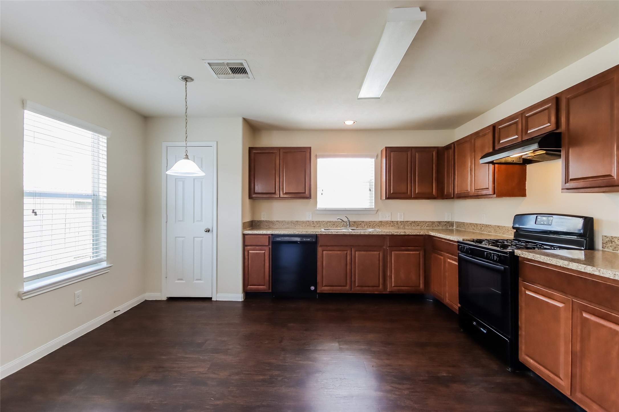 2411 High Island Way Houston, TX 77073 - Photo 4 of 13 a kitchen with stainless steel appliances granite countertop a stove a sink dishwasher a refrigerator and a microwave oven with wooden floor