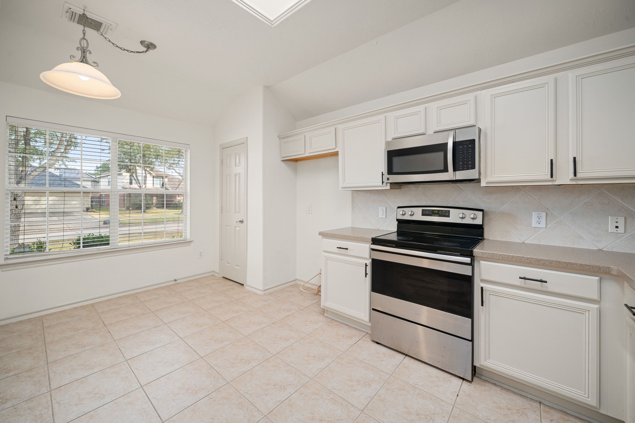 13410 Baron Hill Lane Rosharon, TX 77583 - Photo 13 of 40 a kitchen with granite countertop white cabinets stainless steel appliances and a window