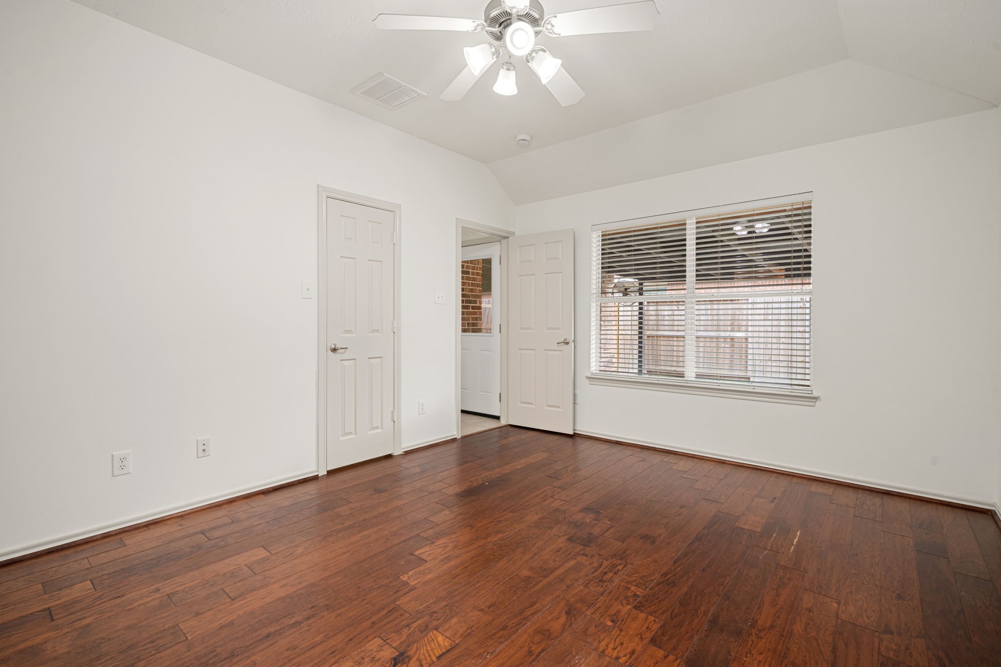 13410 Baron Hill Lane Rosharon, TX 77583 - Photo 21 of 40 an empty room with wooden floor chandelier fan and windows