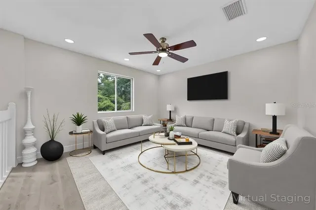 an empty room with wooden floor fan and windows
