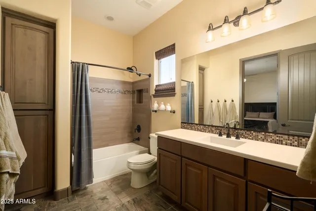 a bathroom with a double vanity sink toilet mirror and shower