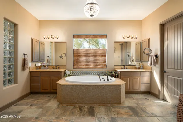 a spacious bathroom with a tub sink and mirror