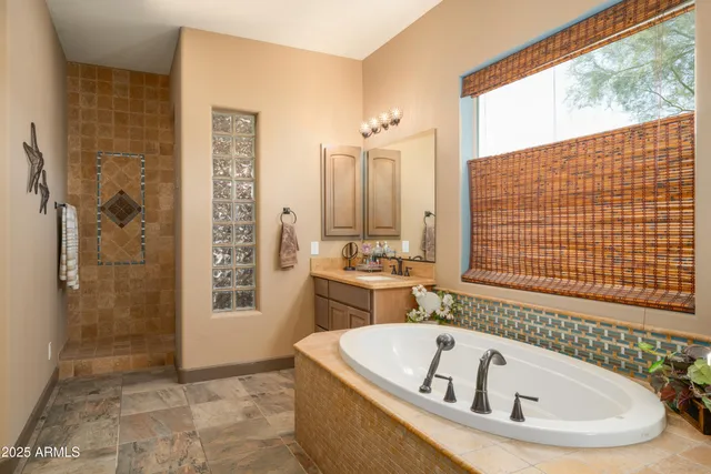 a bathroom with a tub a sink and a shower