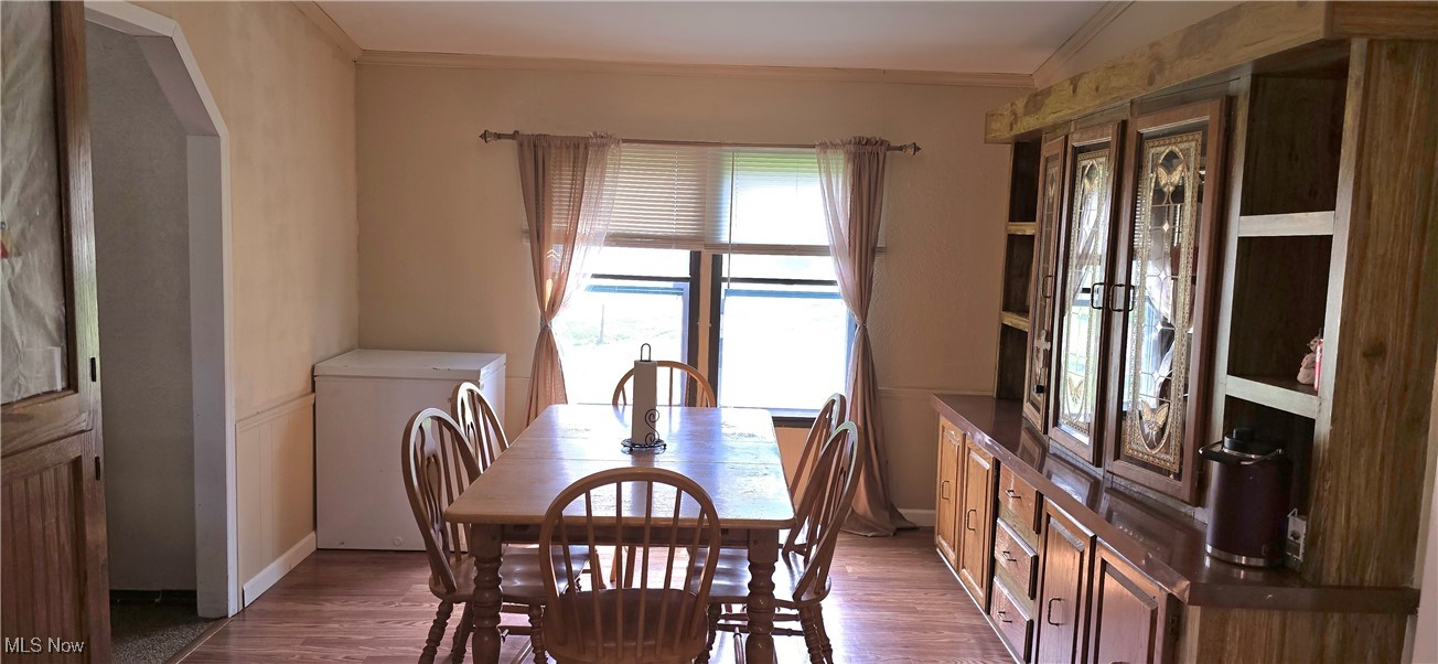 570 Timber Run Road Zanesville, OH 43701 - Photo 15 of 34 Dining area featuring arched walkways, ornamental molding, wood finished floors, and baseboards