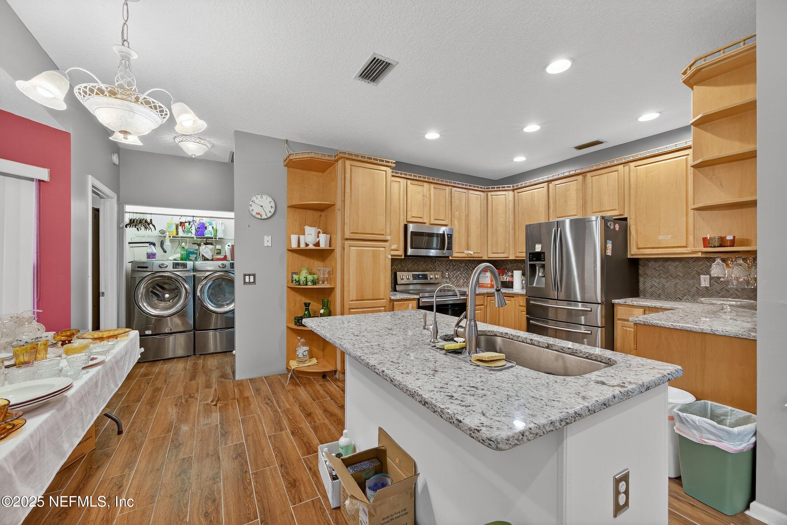 11319 Simmons Road Jacksonville, FL 32218 - Photo 12 of 32 a kitchen with stainless steel appliances granite countertop a sink refrigerator and cabinets