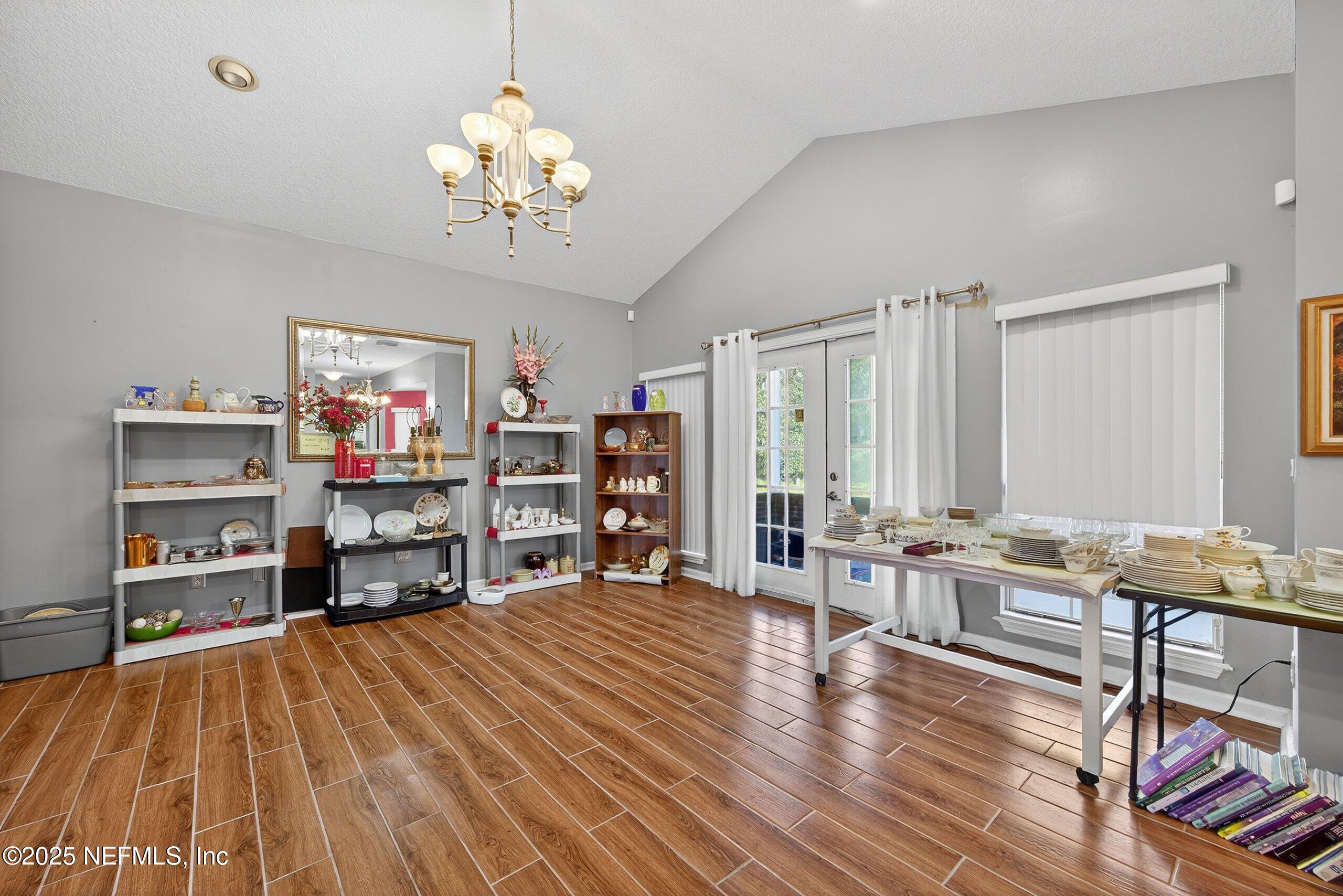 11319 Simmons Road Jacksonville, FL 32218 - Photo 10 of 32 a living room with furniture a chandelier and a flat screen tv