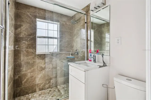 an empty room with a window and ceiling fan