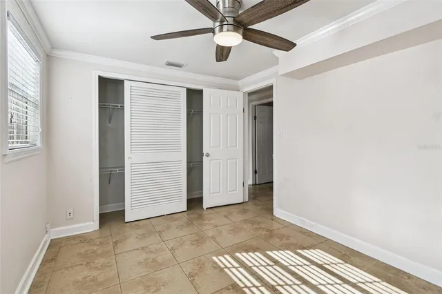 an empty room with fan and windows