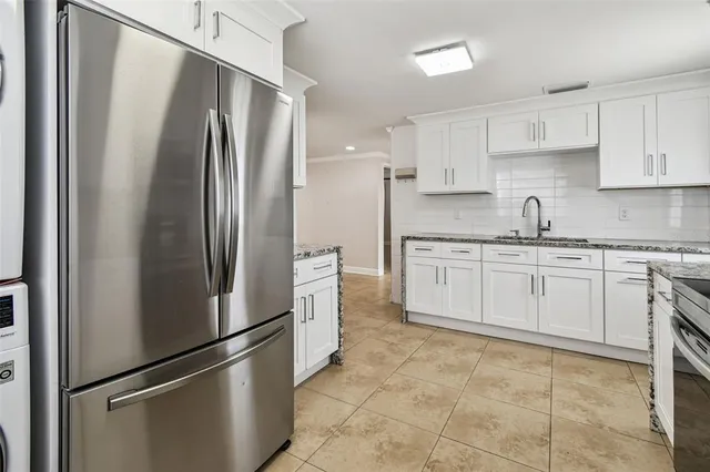 a kitchen with stainless steel appliances a refrigerator sink and cabinets