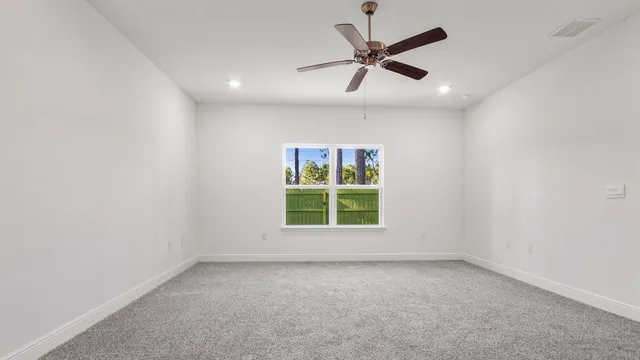 an empty room with a window and a fan