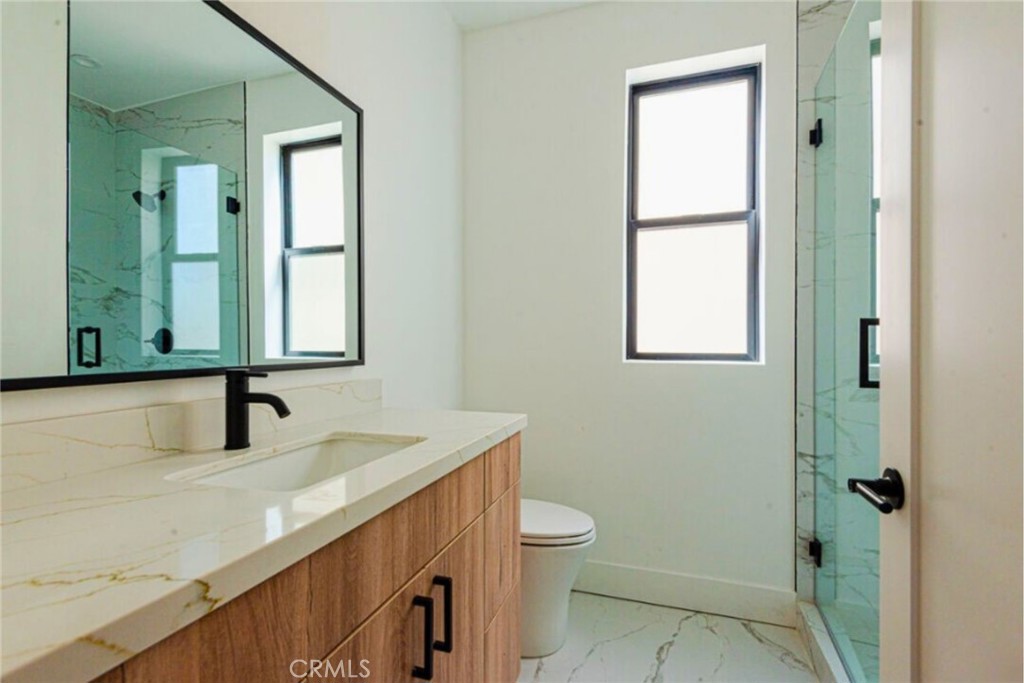 10847 Morrison Street North Hollywood, CA 91601 - Photo 9 of 13 a bathroom with a sink a toilet and a mirror