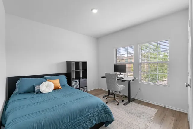 a bedroom with a bed and wooden floor