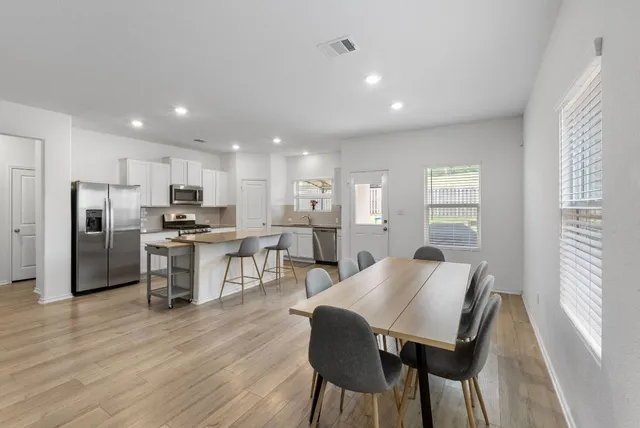 a view of kitchen with refrigerator a microwave and cabinets