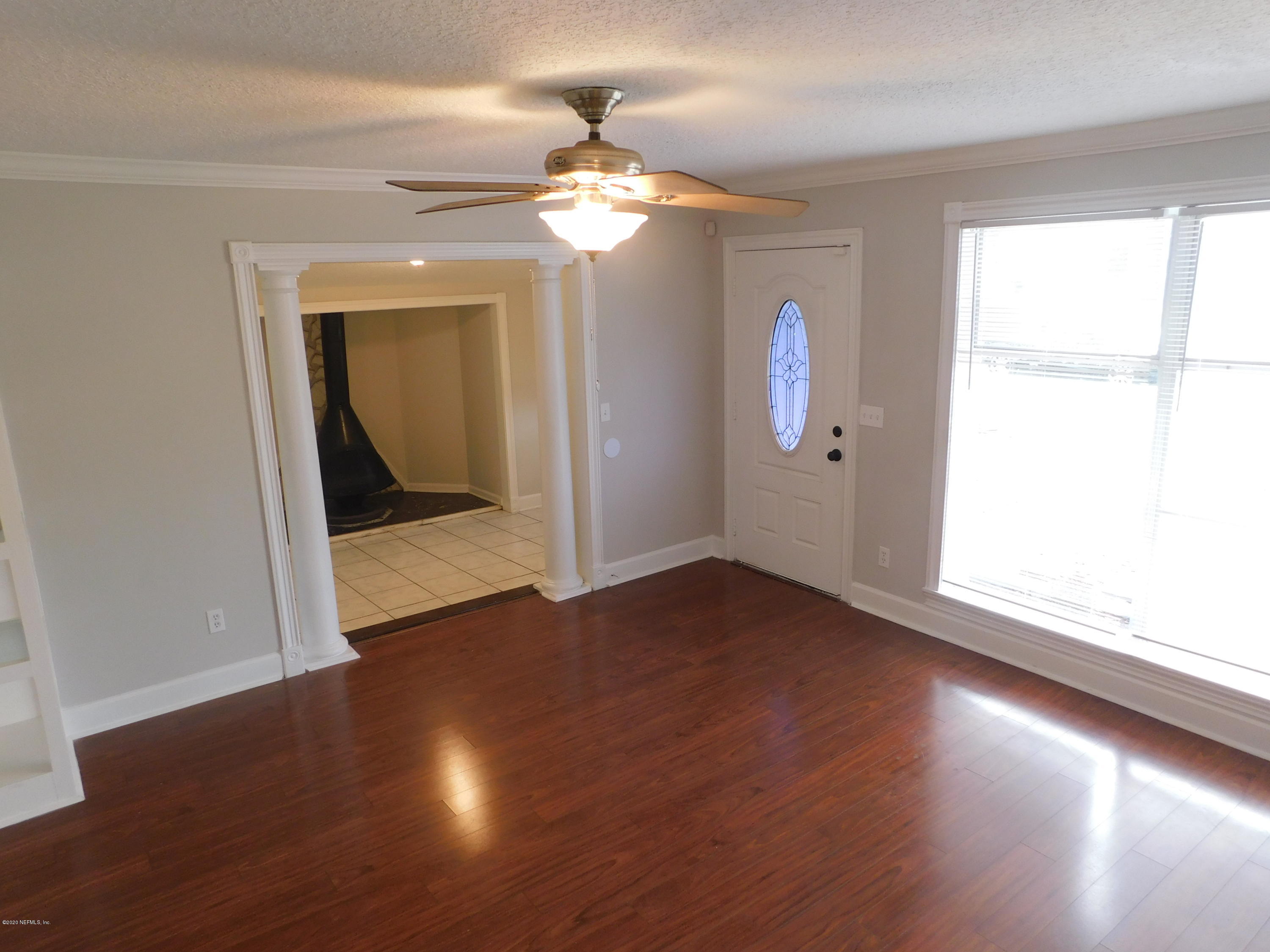 7413 Proxima Road Jacksonville, FL 32210 - Photo 3 of 24 a view of an empty room with wooden floor and a window