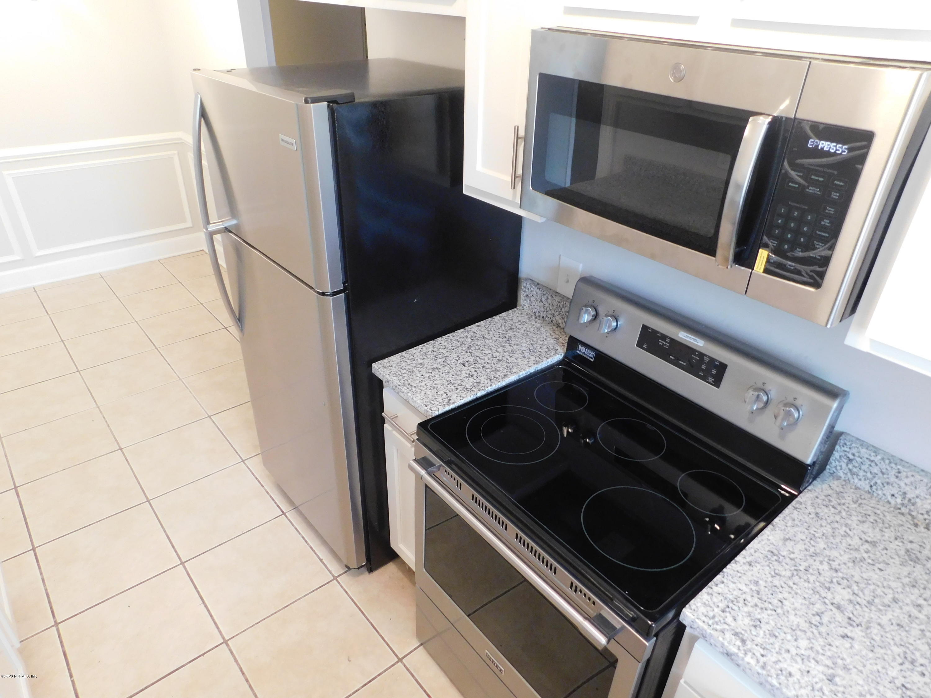 7413 Proxima Road Jacksonville, FL 32210 - Photo 6 of 24 a kitchen with a stove and a microwave