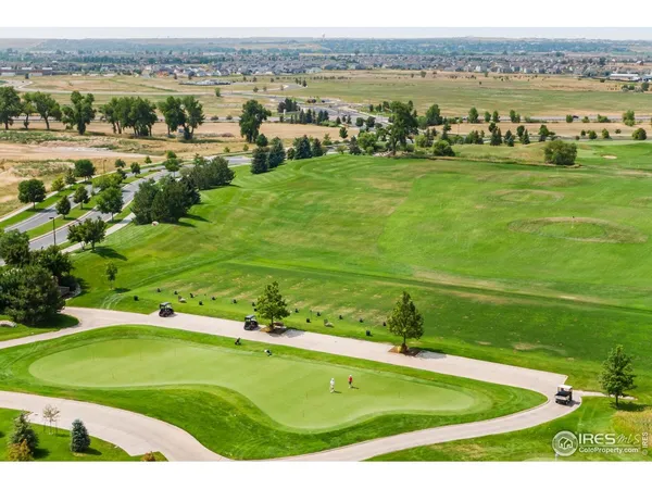 an aerial view of a golf course with a lake view