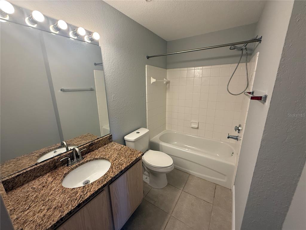 8932 Manor Loop, Unit 205 Lakewood Ranch, FL 34202 - Photo 6 of 15 a bathroom with a granite countertop sink toilet and shower
