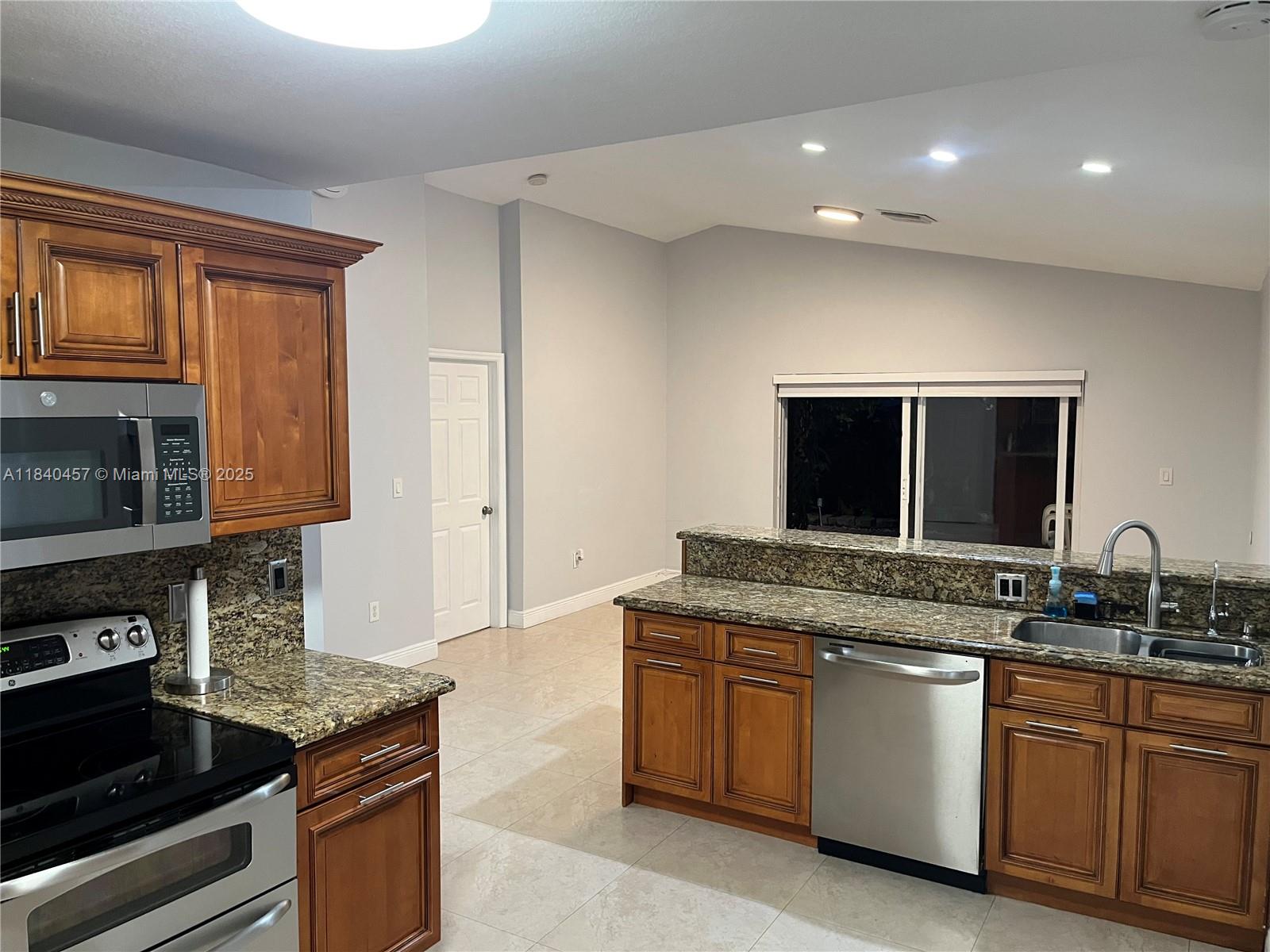 9982 Southwest 162nd Court Miami, FL 33196 - Photo 29 of 97 a kitchen with granite countertop a stove and a sink