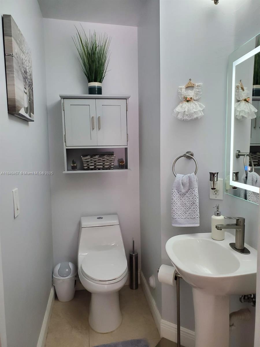 9982 Southwest 162nd Court Miami, FL 33196 - Photo 40 of 97 a bathroom with a toilet a sink and a mirror