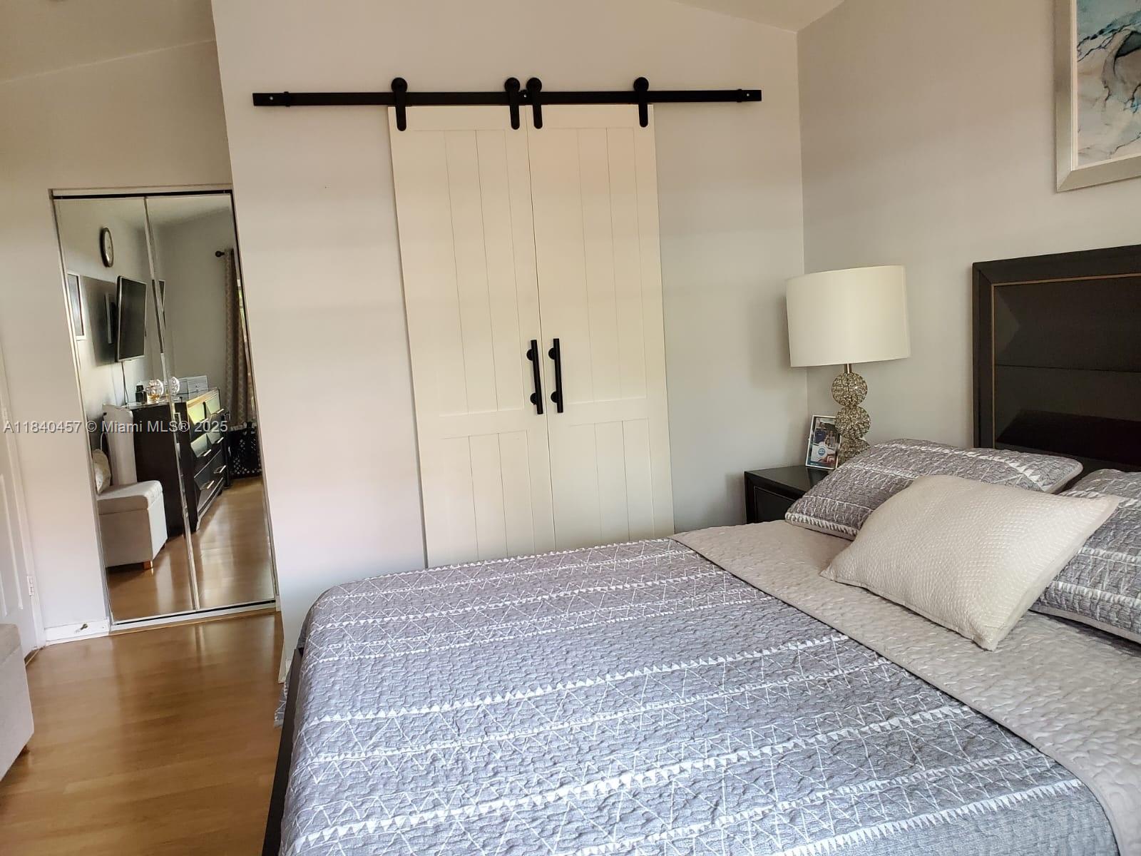 9982 Southwest 162nd Court Miami, FL 33196 - Photo 44 of 97 a bedroom with a bed and a flat tv screen on the dresser