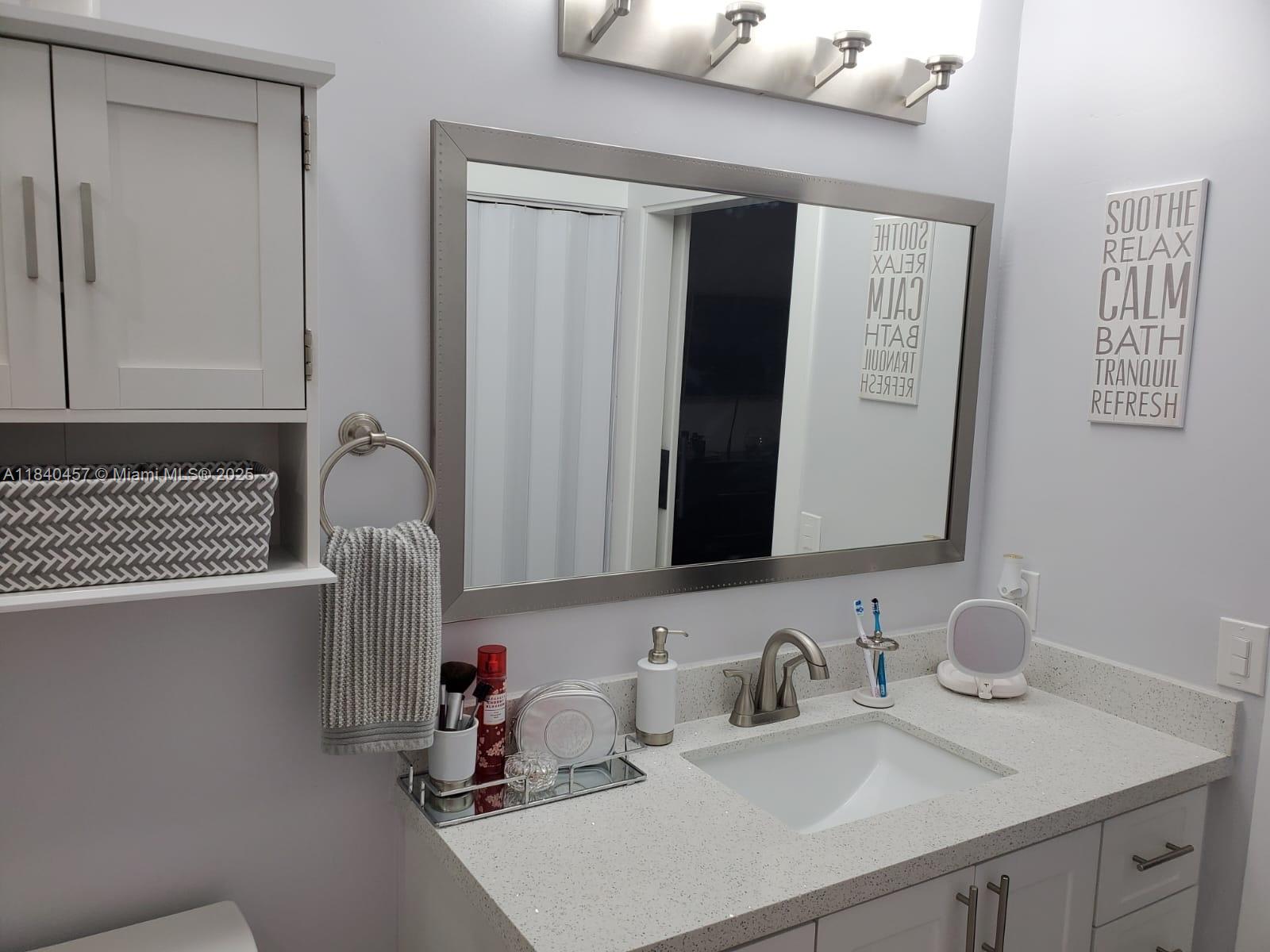 9982 Southwest 162nd Court Miami, FL 33196 - Photo 60 of 97 a bathroom with a sink and a mirror