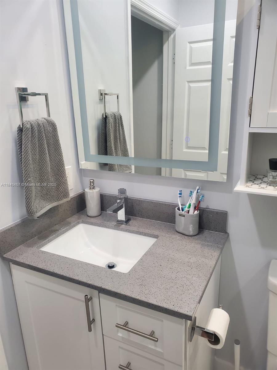 9982 Southwest 162nd Court Miami, FL 33196 - Photo 64 of 97 a bathroom with a sink and a mirror