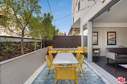 a backyard of a house with barbeque oven table and chairs