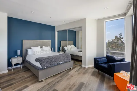 a bedroom with furniture and a large window