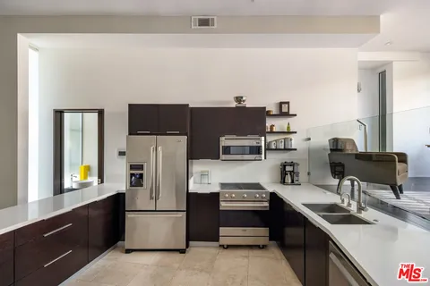 a kitchen with stainless steel appliances a refrigerator stove and sink