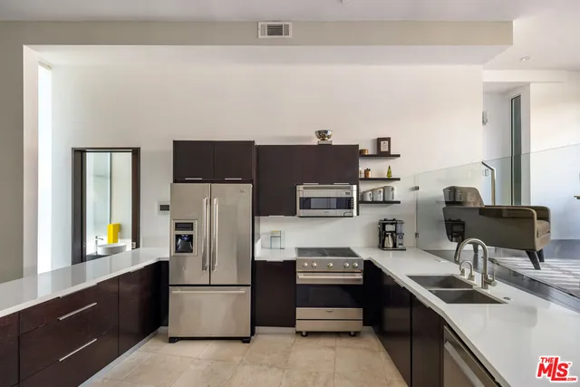 a kitchen with stainless steel appliances a refrigerator stove and sink