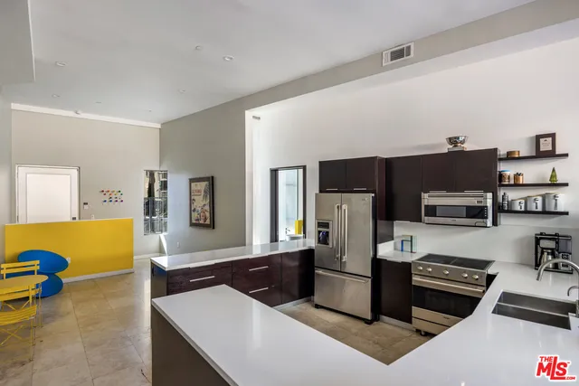 a kitchen with stainless steel appliances a stove a refrigerator a sink a stove and a refrigerator