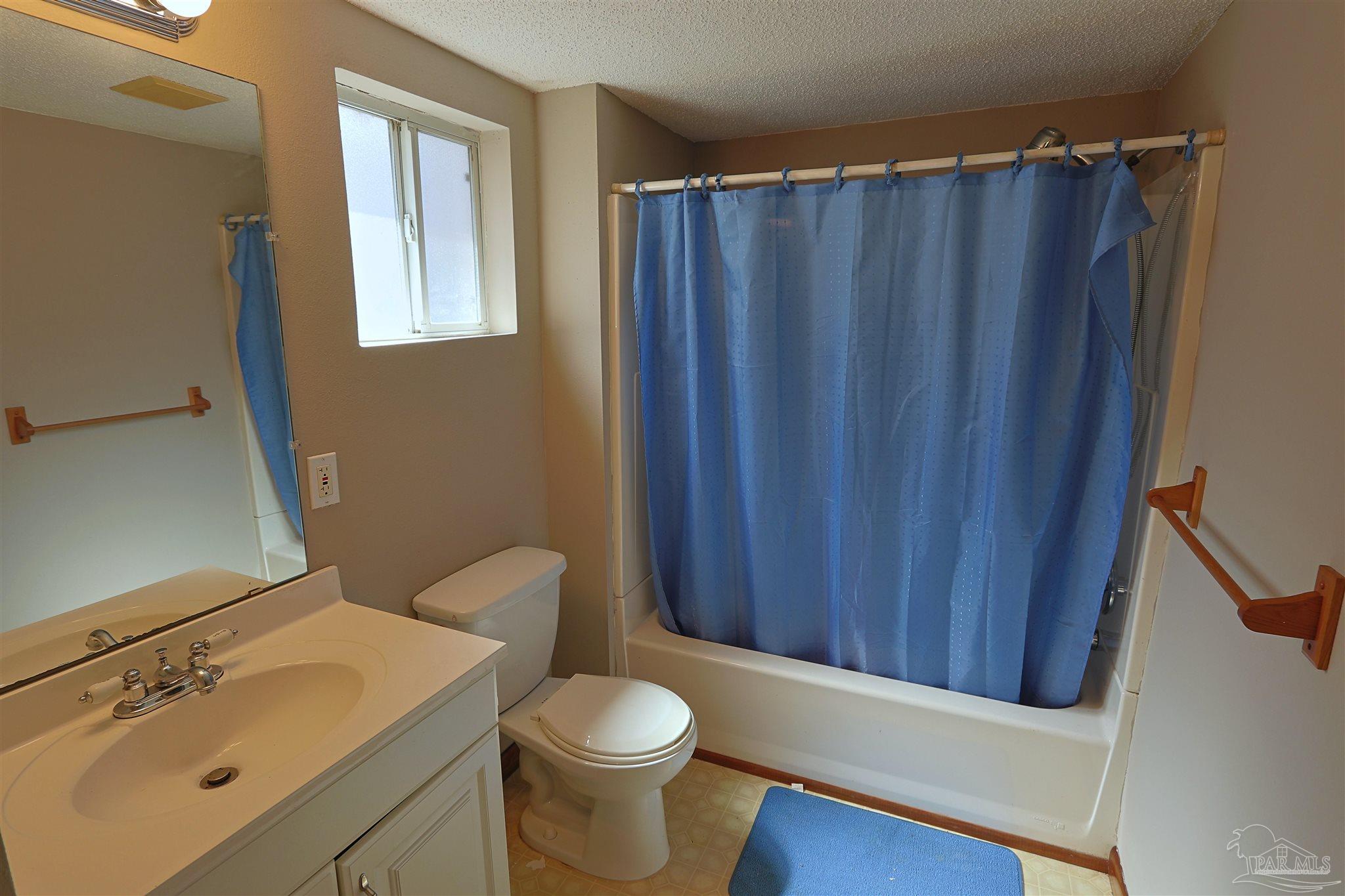 6941 Camp Henderson Road Jay, FL 32565 - Photo 11 of 17 a bathroom with a sink a toilet and shower curtain
