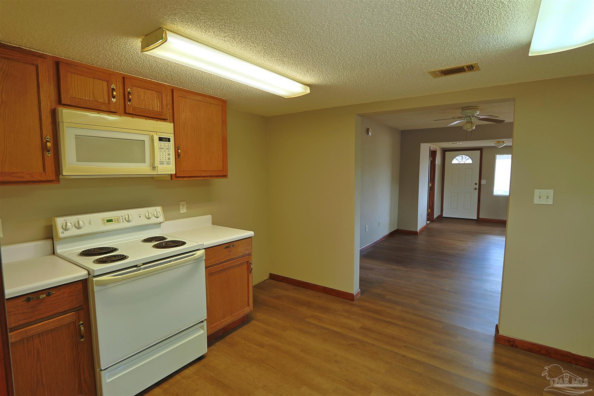 6941 Camp Henderson Road Jay, FL 32565 - Photo 6 of 17 a kitchen with wooden floor and cabinets