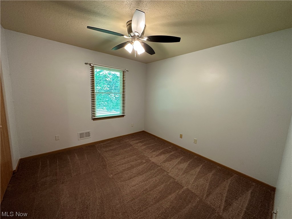 6431 Shaffer Road Northwest Warren, OH 44481 - Photo 10 of 20 Carpeted spare room with ceiling fan and a textured ceiling
