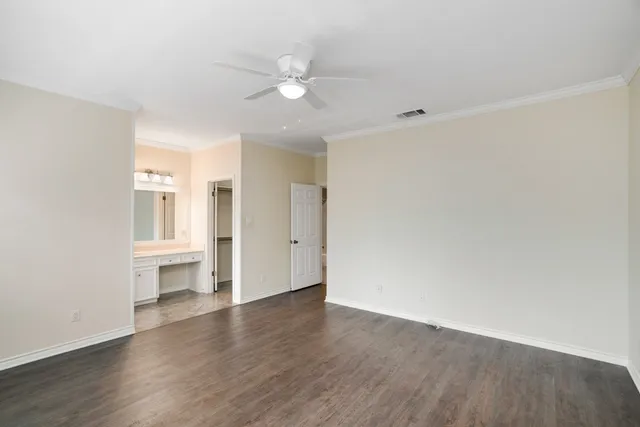 a view of a kitchen with wooden floor and white walls