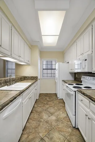 a large kitchen with a stove top oven sink and cabinets