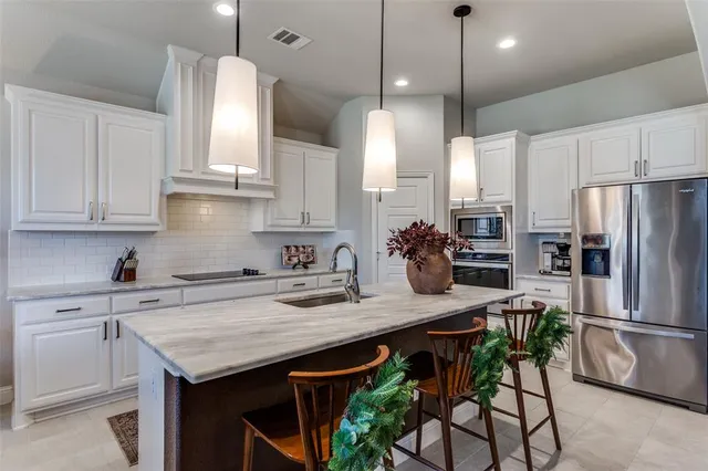 a kitchen with stainless steel appliances granite countertop a table chairs stove refrigerator and cabinets