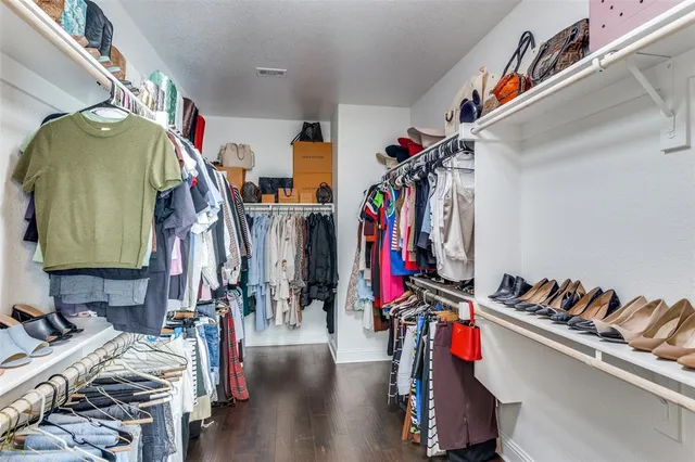 a view of walk in closet with clothes and shoes