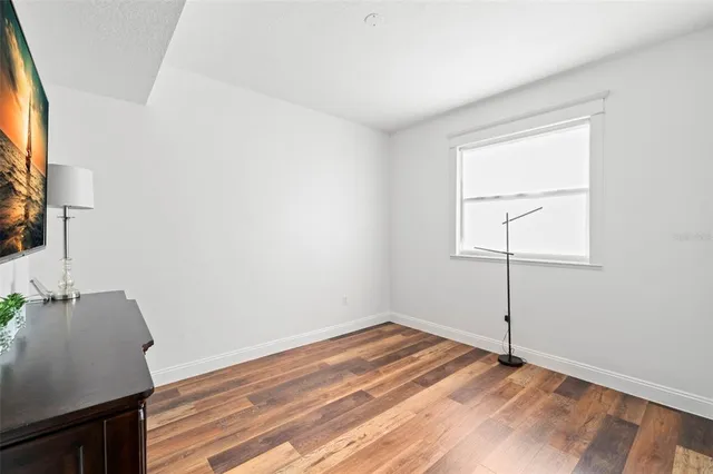 a view of an empty room with wooden floor and entryway