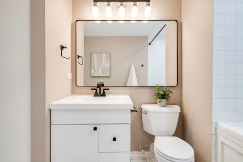 a bathroom with a toilet sink and mirror
