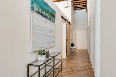 a view of a hallway with wooden floor and staircase
