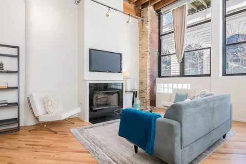 a living room with furniture a flat screen tv and a fireplace