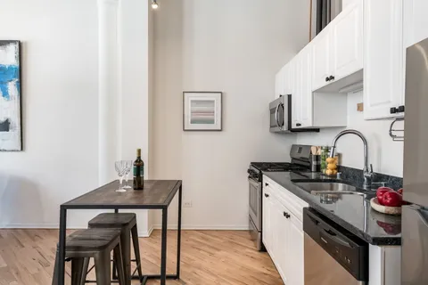 a kitchen with stainless steel appliances granite countertop a sink stove and cabinets