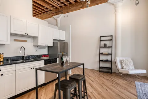 a kitchen with stainless steel appliances granite countertop a stove top oven a sink dishwasher and cabinets with wooden floor