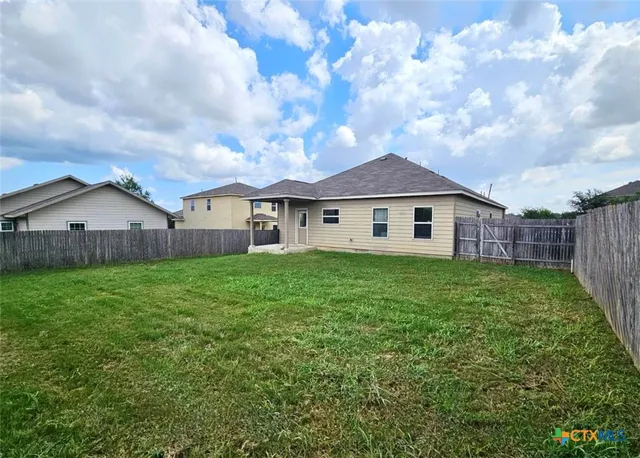 a view of a house with a big yard and large tree
