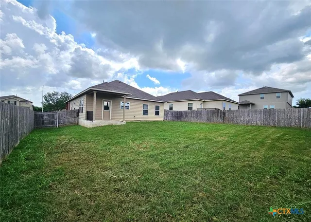 a view of a house with backyard and garden