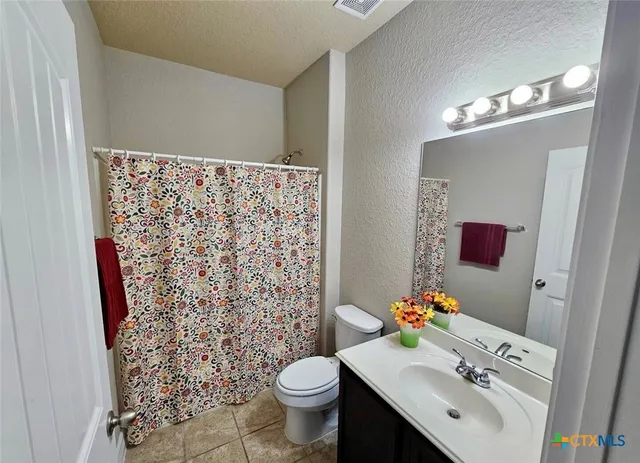 a bathroom with a sink toilet and a mirror